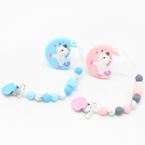 Detail of pink and blue silicone pacifier clips with unicorn pendants and marble beads