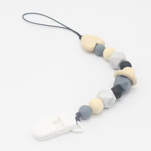 Detail showing silicone beads and wooden heart on minimalist baby pacifier clip chain