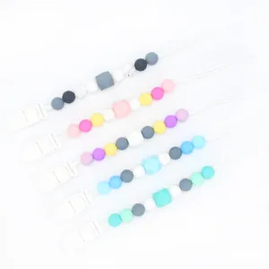 Detailed view of silicone pacifier clips with colorful beads and secure plastic fasteners