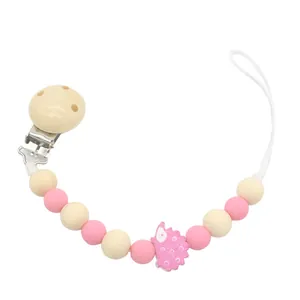 Baby Schnullerkette aus rosa Silikon und Holz mit Igel-Anhänger auf weißem Grund