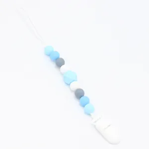 Close-up of silicone pacifier clip with multi-colored blue and grey hexagonal beads