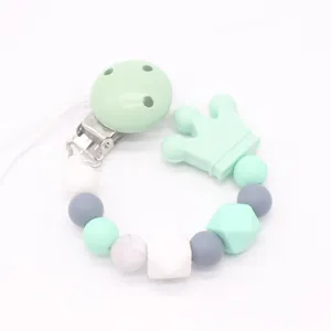 Detail of baby pacifier clip with mint green silicone crown and marble texture beads