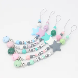 Close-up of five silicone pacifier clips with macaron beads and baby letter cubes