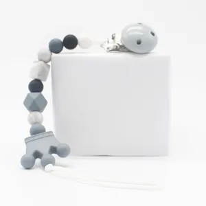 Close-up of silicone baby pacifier clip with marble beads and gray crown pendant detail