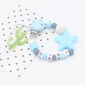Detail of baby pacifier clip with blue silicone stars, baby beads and wooden metal clip