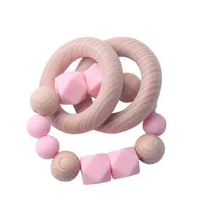 Natural beech wood and pink silicone baby teether ring set on a clean white background