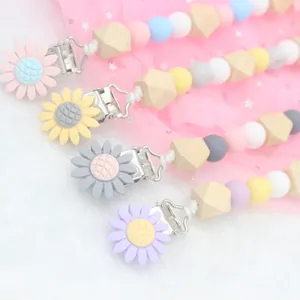 Set of four silicone and wooden baby pacifier clips with daisy flower designs