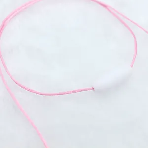 Detail van roze geweven koord met witte veiligheidssluiting op zachte pluche