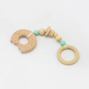 Détail de l'anneau de dentition en bois de hêtre et perles en silicone vert macaron