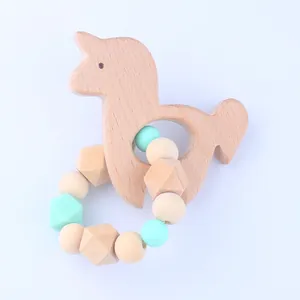Detailed view of unicorn beech wood teether with mint green silicone bead ring