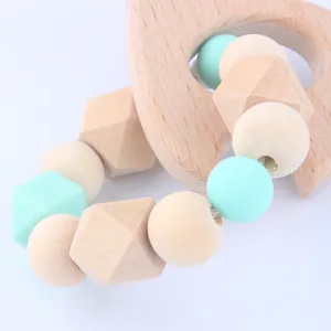 Close-up of beech wood ring and mint green silicone beads on a baby teething pacifier chain