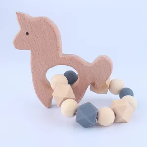 Detail of wooden alpaca teether and silicone beaded ring with a minimalist design