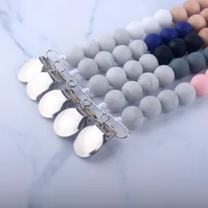 Detail of baby pacifier clips featuring silicone and beech wood beads with metal clips