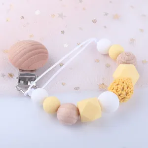 Détail de l'attache-tétine pour bébé avec perles en silicone jaune et clip en bois