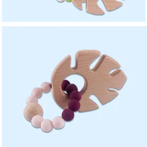 Detail eines blattförmigen Beißrings aus Buchenholz mit lila und rosa Silikonperlen