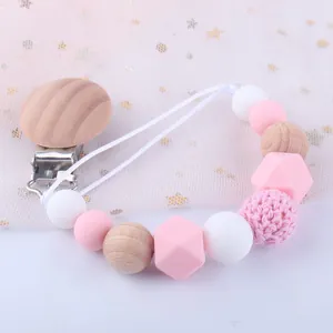 Détail de l'attache-tétine en silicone et perles de bois en rose et blanc pur