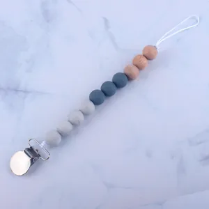 Close-up of silicone beads and beech wood clip on baby dummy chain with marble pattern