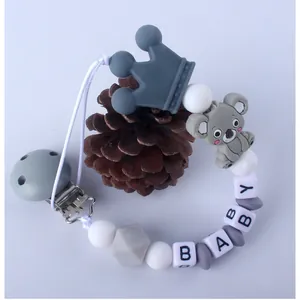Detalle de cadena para chupete de silicona con koala gris, corona y perlas de letra BABY