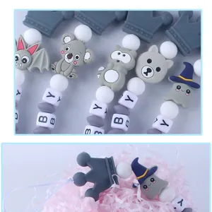 Detalle de sujetachupetes de silicona con figuras de animales y cuentas de letras BABY
