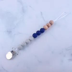 Detail of baby pacifier clip with marble silicone beads, wood accents, and metal clasp