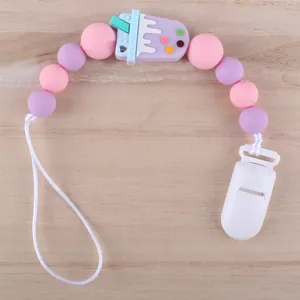 Details zur Silikon-Schnullerkette mit lila Eiscreme-Anhänger auf Holzgrund