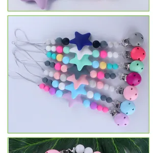 Vista plana de 8 sujetachupetes de silicona coloridos con cuentas de estrella y clips
