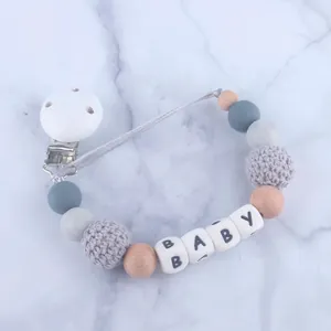 Detail eines Schnullerketten-Clips mit Silikon- und Holzperlen sowie BABY-Buchstaben