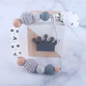 Baby Schnullerkette aus Silikon und Holz mit BABY Buchstabenperlen auf Marmor