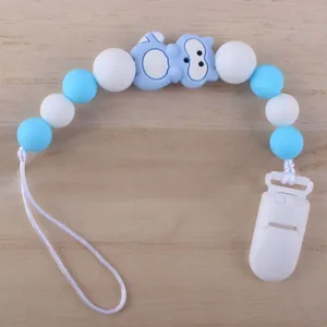 Nahaufnahme von Schnullerkette mit blauen Silikonperlen und Cartoon-Anhänger auf Holzboden