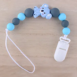 Blaue Koala Baby Schnullerkette mit Silikonperlen auf einem natürlichen Holzhintergrund