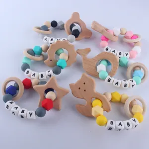 Dettaglio di braccialetti per la dentizione con ciondoli in legno e perline in silicone