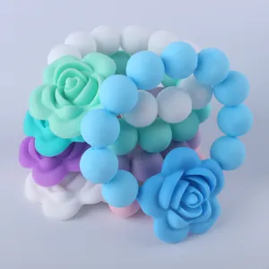 Dettaglio di braccialetti da dentizione in silicone alimentare con rosa decorativa