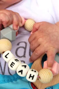 Dettaglio di un anello da dentizione personalizzato in silicone e faggio con il nome Leah per bimbi