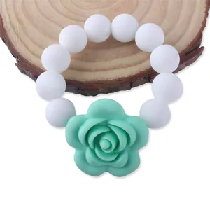 Bracciale dentizione neonato in silicone con perle bianche e ciondolo a rosa verde menta