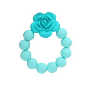 Dettaglio del massaggiagengive in silicone turchese con rosa e morbide perle rotonde