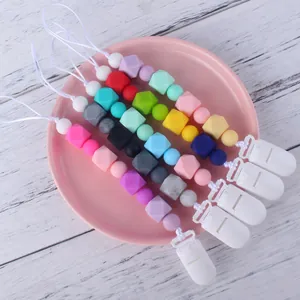 5-pack silicone pacifier clips with colorful beads for babies on a pink decorative plate