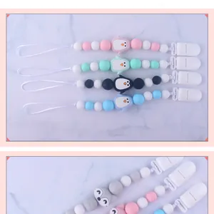 Close-up of silicone pacifier clip with colorful beads and cartoon animal charms