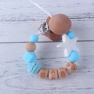 Detalle de sujetachupetes con cuentas de silicona, estrella de madera y cubos de BABY