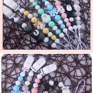 Detail of colorful silicone pacifier clip with cute animal shapes on woven background