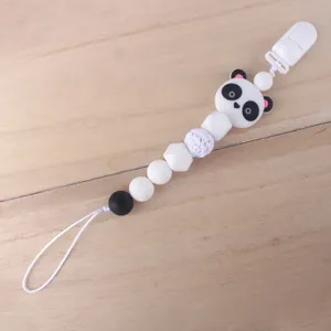 Detalle de sujetachupetes de silicona con diseño de panda y cuenta de ganchillo en madera