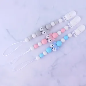 Detail of silicone pacifier clips with fox beads in grey, pink, and blue colors