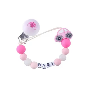 Detail of pink silicone pacifier clip with baby beads and car-shaped teething pendant