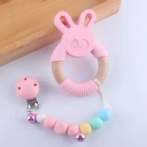 Detail of pink silicone rabbit teether with wooden ring and colorful pacifier clip chain
