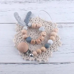 Détail de l'attache-tétine en bois de hêtre avec perles en silicone et lettres BABY
