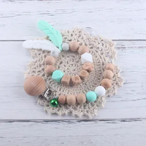 Détail de l'attache-tétine et de l'anneau de dentition en bois et silicone vert menthe