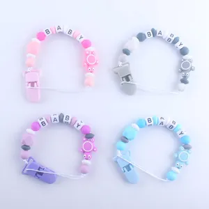 Detalle de cuatro sujetachupetes de silicona de colores con cuentas BABY y clips