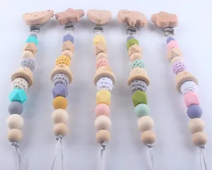 Detail of colorful silicone pacifier clips with wooden animal shapes and crochet beads