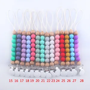 Detail showing various colors of silicone and wood bead pacifier clips with metal fasteners