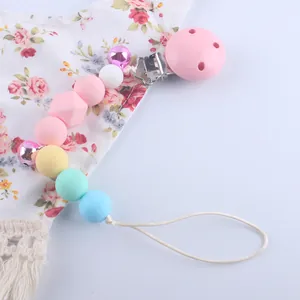 Detailed macro view of macaron colored silicone beads and pink clip on baby pacifier chain