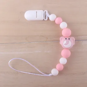 Detailed close-up of pink and white silicone pacifier clip with small elephant bead